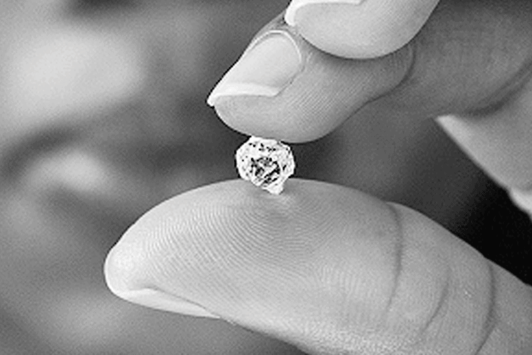 Laboratory professional performing a detailed examination of a gemstone under analysis for the SGL course.