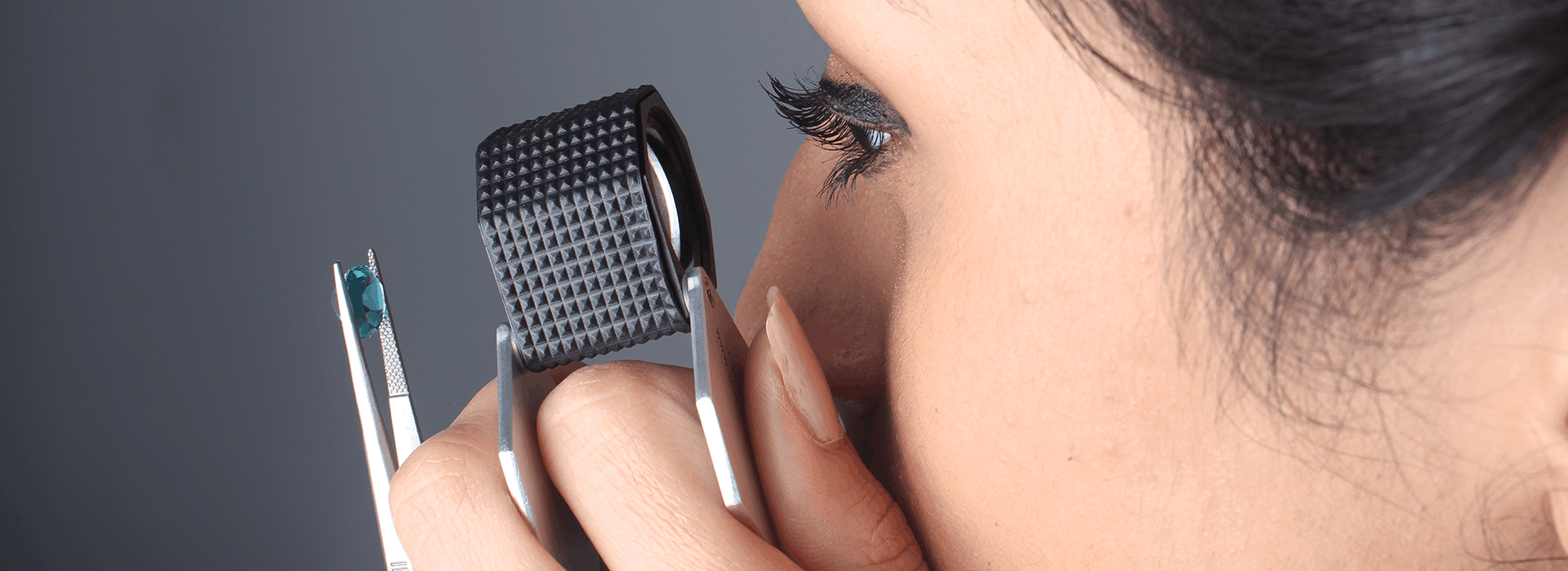 Close-up of a gemologist using a laboratory loupe to perform high-precision gemstone grading.