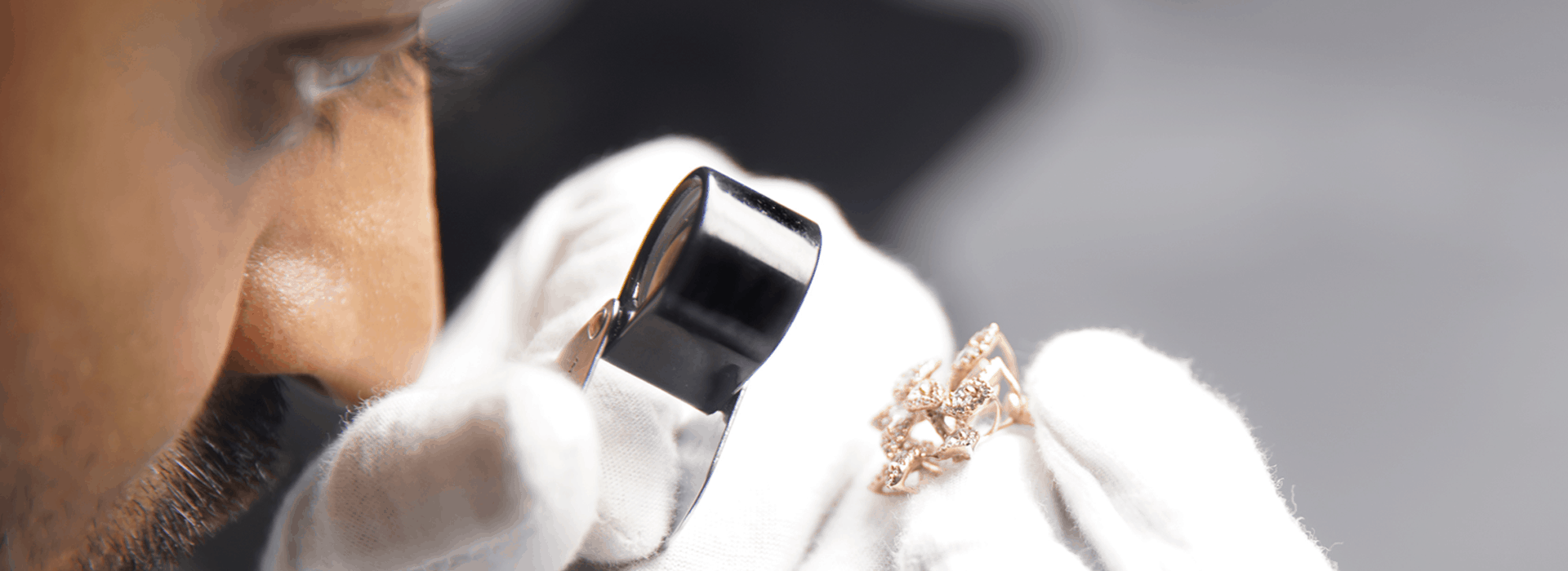 Professional gemologist working at a laboratory microscope to perform technical stone grading.