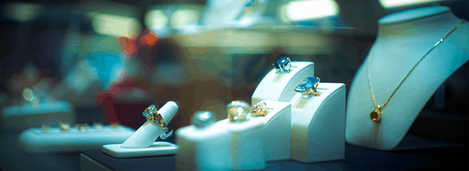 Luxury jewelry showroom display featuring diamond necklaces on mannequins, representing career paths in retail management.