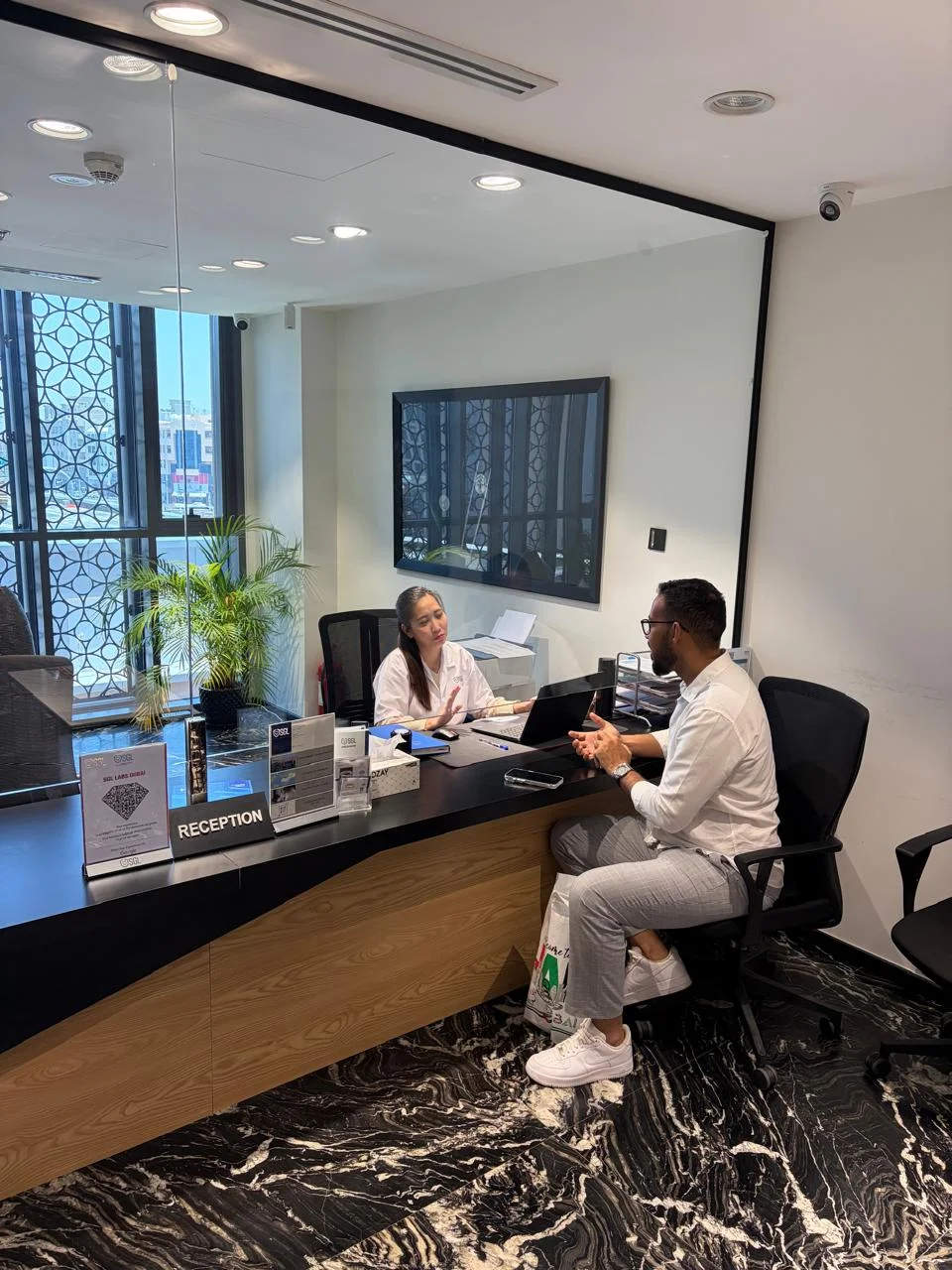 Client reception desk at SGL Labs Deira, Dubai for diamond testing and certification.